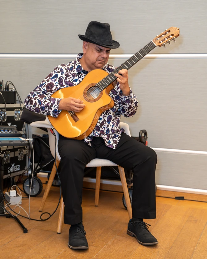 Arturo Romay plays his acoustic guitar in the Norton Museum's Great Hall